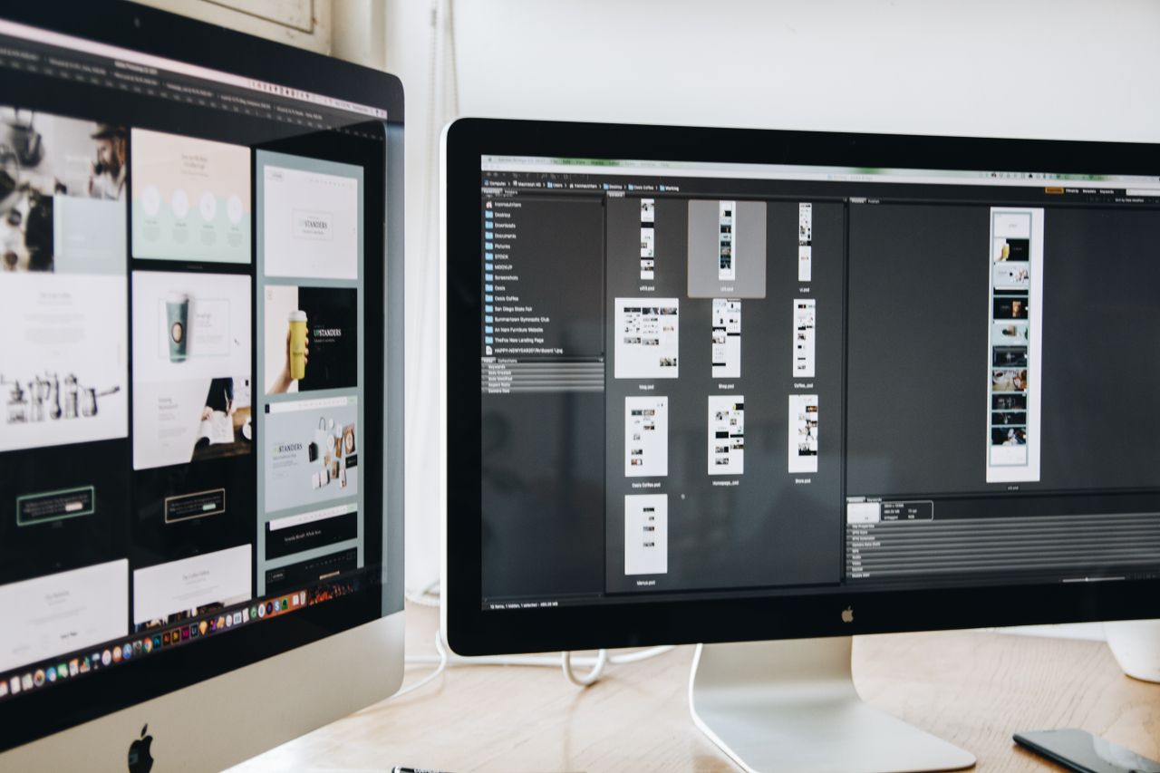 services-04 Moderní pracovní prostor s dvěma počítačovými monitory zobrazujícími webdesignové projekty, který zdůrazňuje technologie a produktivitu.